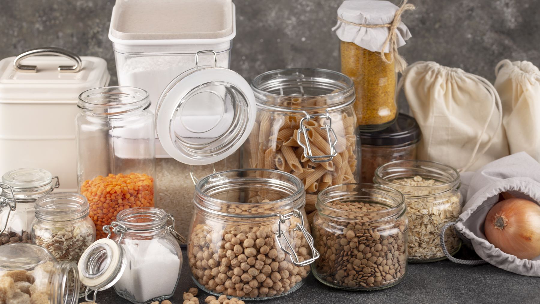 Jars of rice, pasta, lentils, chickpeas and flour arranged together